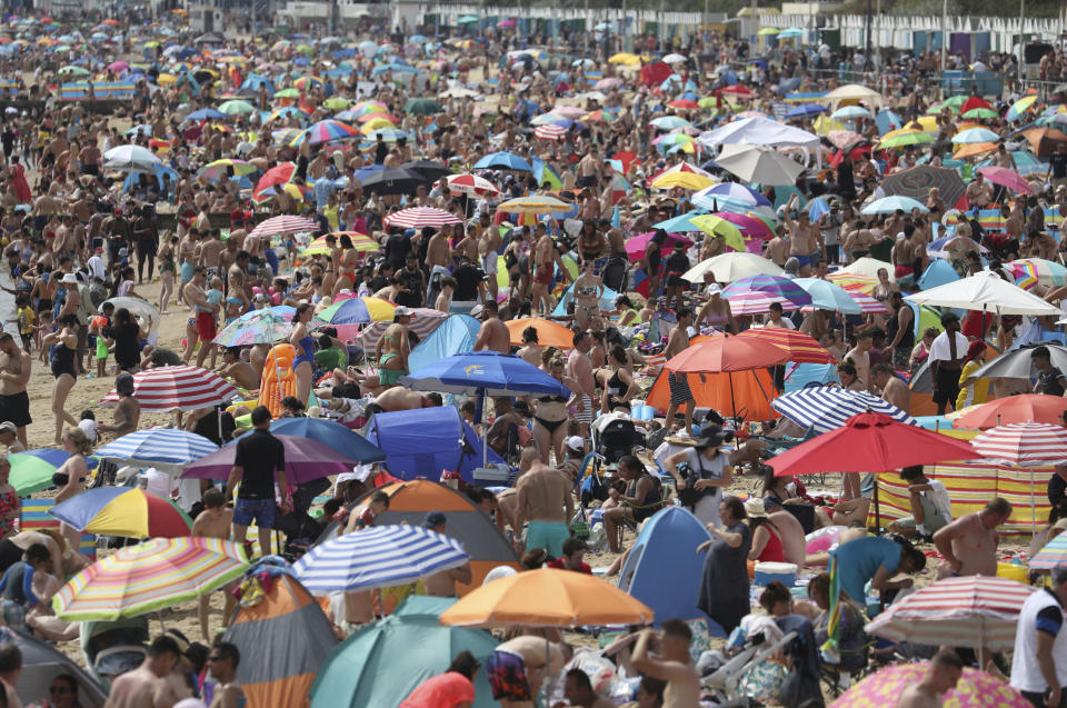People enjoy the hot weather on Bournemouth beach, England, Saturday Aug. 8, 2020. Parts of the UK could see record-breaking overnight temperatures this weekend as the mini heatwave continues. (Andrew Matthews/PA via AP)