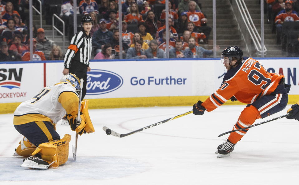 Nashville Predators goalie Juuse Saros (74) makes a save against Edmonton Oilers' Connor McDavid (97) during second-period NHL hockey game action in Edmonton, Alberta, Saturday, Feb. 8, 2020. (Jason Franson/The Canadian Press via AP)