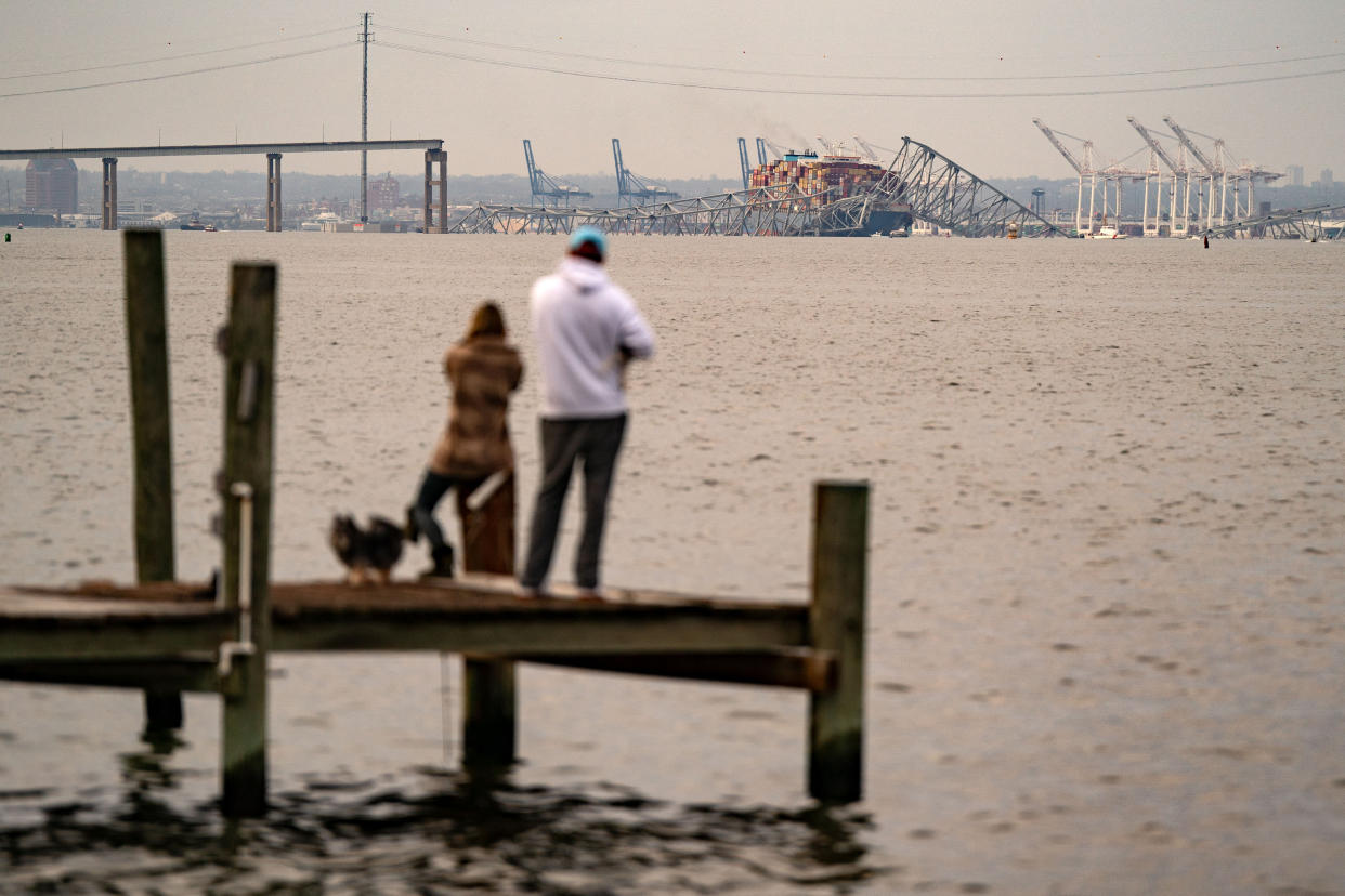 People look out toward the Francis Scott Key Bridge following its collapse
