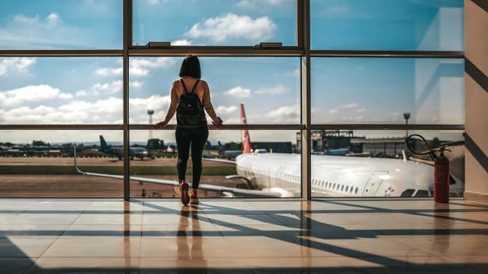 A woman at the airport looking out the window