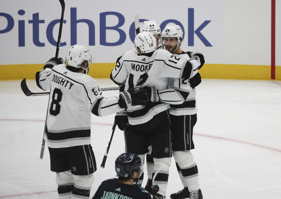 Los Angeles Kings center Phillip Danault at right celebrates his goal against the Seattle Kraken with Los Angeles Kings defenseman Drew Doughty (8), center Trevor Moore (12) and defenseman Mikey Anderson (44) during the second period of an NHL hockey game, Saturday, Jan. 15, 2022, in Seattle. (AP Photo/Lindsey Wasson)