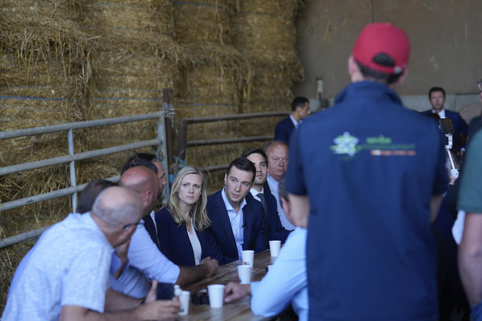 Jordan Bardella far-right National Rally leader for the upcoming election, center, meets farmers as he visits a farm in Chuelles, 137 kms (85 miles) south of Paris, Friday, June 14, 2024. The election is to take place in two rounds on June 30 and July 7. (AP Photo/Thibault Camus)