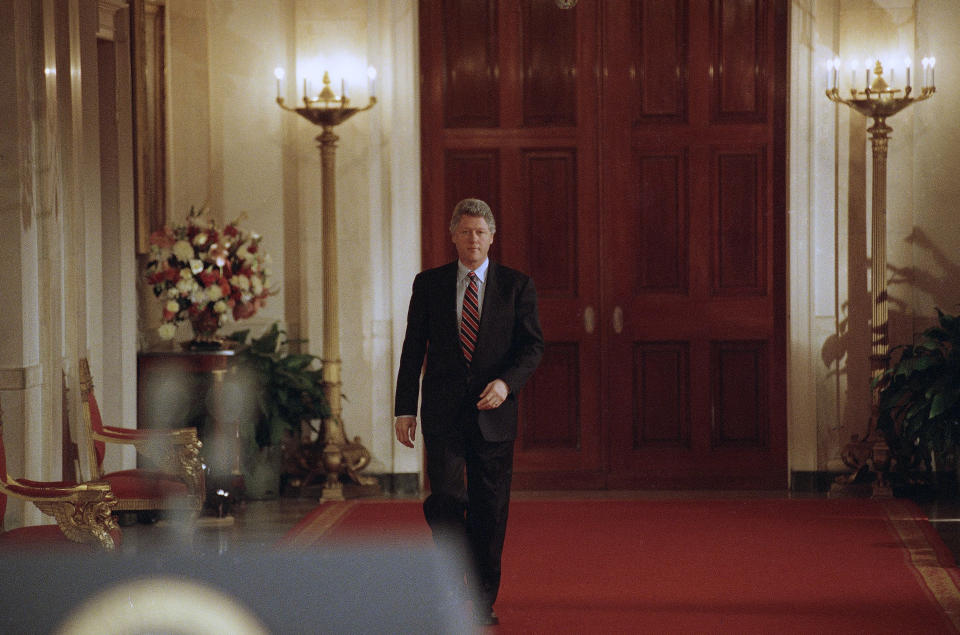 FILE - In this March 23, 1993, file photo, President Bill Clinton walks through the Grand Foyer to the East Room of the White House in Washington going to his first formal news conference. (AP Photo/Ron Edmonds, File)