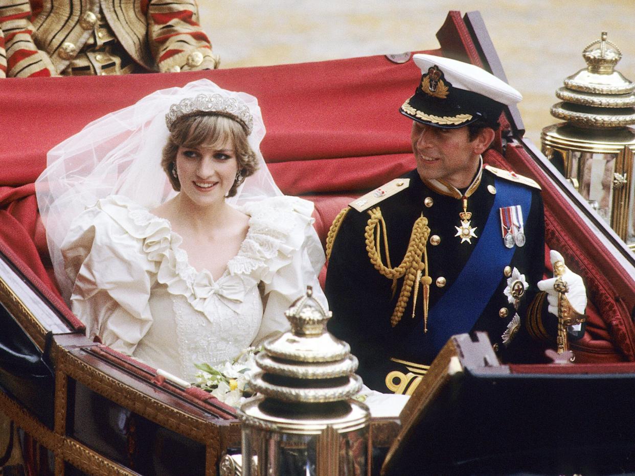 Prince Charles, Prince of Wales and Diana, Princess of Wales, wearing a wedding dress designed by David and Elizabeth Emanuel and the Spencer family Tiara, ride in an open carriage, from St. Paul's Cathedral to Buckingham Palace, following their wedding on July 29, 1981 in London, England