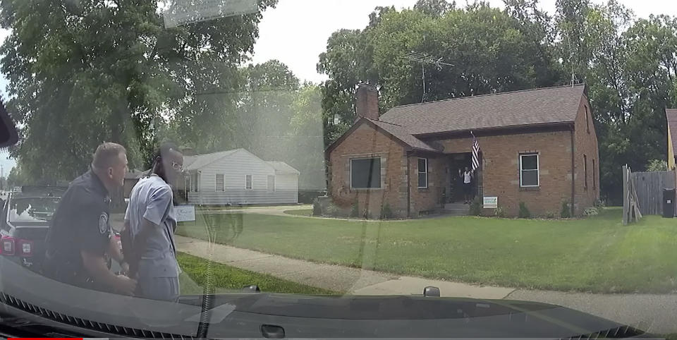 This Aug. 1, 2021 image from video provided by the Wyoming, Mich., Police Department shows a Wyoming Officer handcuffing real estate agent Eric Brown outside a home he was showing to a potential buyer in Wyoming, Mich. Police handcuffed the realtor, his client and that man's 15-year-old son this month after a neighbor wrongly reported the three Black people were breaking into a home. (Wyoming Police Department via AP)