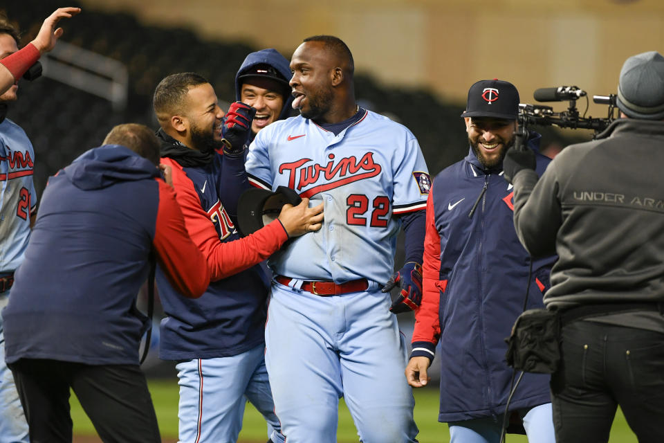 Minnesota Twins' Miguel Sano (22) celebrates teammates after he hit a single against the Detroit Tigers during the ninth inning of a baseball game, Tuesday, April 26, 2022, in Minneapolis. There was an error on the play, and the Twins scored two runs, winning 5-4. (AP Photo/Craig Lassig)