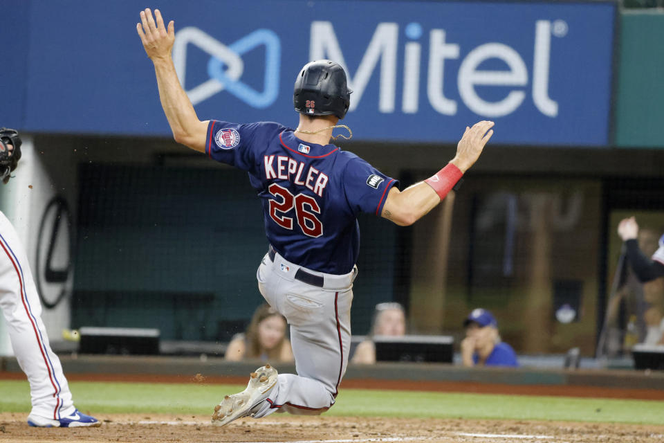 Minnesota Twins' Max Kepler (26) scores against the Texas Rangers during the seventh inning of a baseball game Saturday, June 19, 2021, in Arlington, Texas. (AP Photo/Michael Ainsworth)