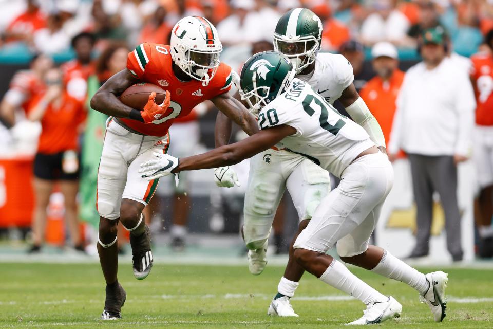 Miami wide receiver Romello Brinson (0) stiff-arms Michigan State cornerback Emmanuel Flowers (20) during the fourth quarter of an NCAA college football game, Saturday, Sept. 18, 2021, in Miami Gardens, Fla.