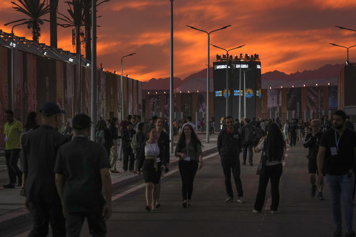 FILE - Attendees walk at the COP27 U.N. Climate Summit at sunset, Nov. 14, 2022, in Sharm el-Sheikh, Egypt. (AP Photo/Peter Dejong, File)
