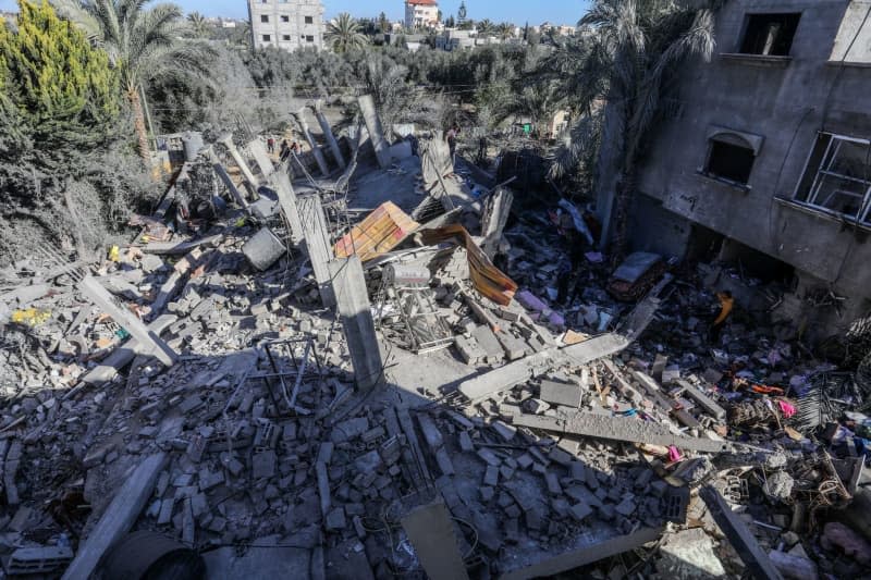 Palestinians inspect the destruction following an Israeli airstrike on a house belonging to the Al-Faqawi family. Abed Rahim Khatib/dpa