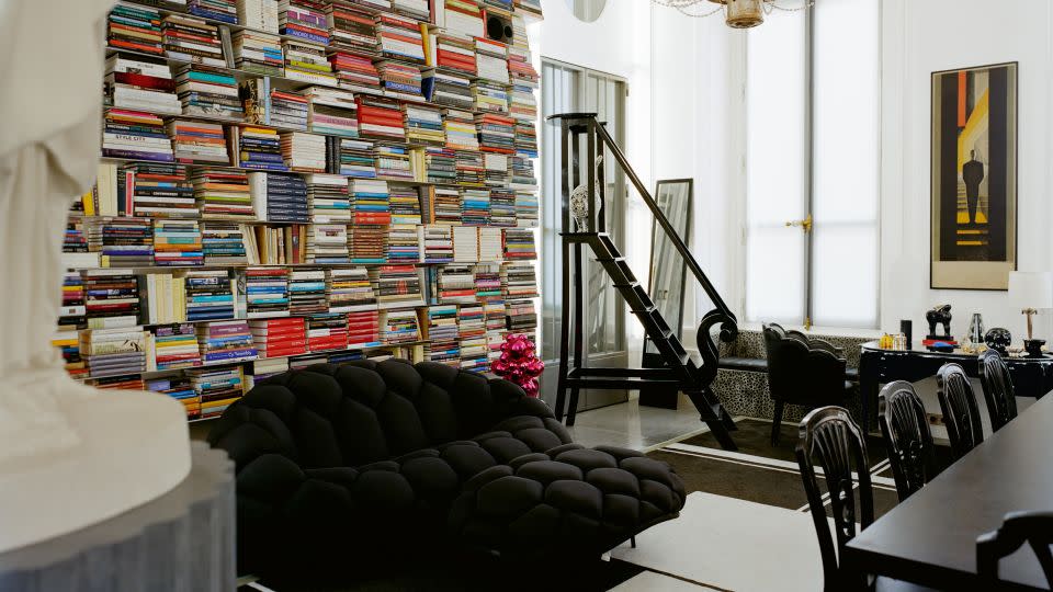 The library space inside Lagerfeld's apartment on Rue des Saints Pères in Paris, featuring artworks by Jeff Koons and Joana Vasconcelas (who designed the statue of the designer's cat, Choupette, that can be seen posing on the black ladder in the back of the photo) among others. - François Coquerel/Courtesy Thames & Hudson
