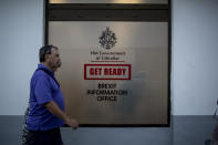 People walk past a Brexit information office during general elections in Gibraltar, Thursday Oct. 17, 2019. An election for Gibraltar's 17-seat parliament is taking place Thursday under a cloud of uncertainty about what Brexit will bring for this British territory on Spain's southern tip.(AP Photo/Javier Fergo)