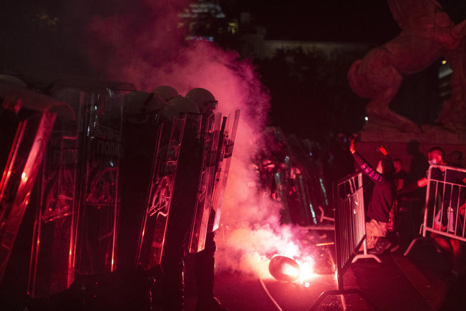 Riot police form a line on the steps of the Serbian parliament as protesters try to storm the building in Belgrade, Serbia, Friday, July 10, 2020. Hundreds of mostly far right supporters on Friday tried to storm the national parliament in Belgrade, targeting the police for the fourth night of protests against the Serbian president and his rule amid a spike in coronavirus cases in the Balkan country. (AP Photo/Marko Drobnjakovic)