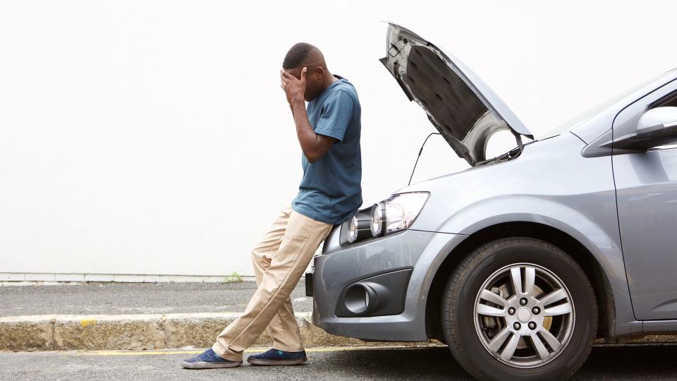 man with broken down car