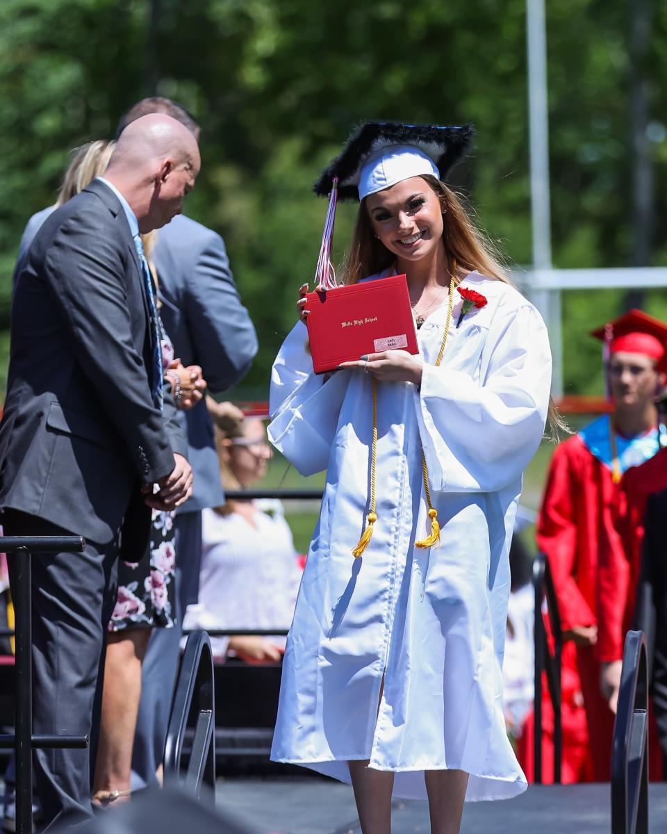 Laci Raso proudly displays her diploma from the stage during the Wells High School Commencement Sunday, June 5, 2022.