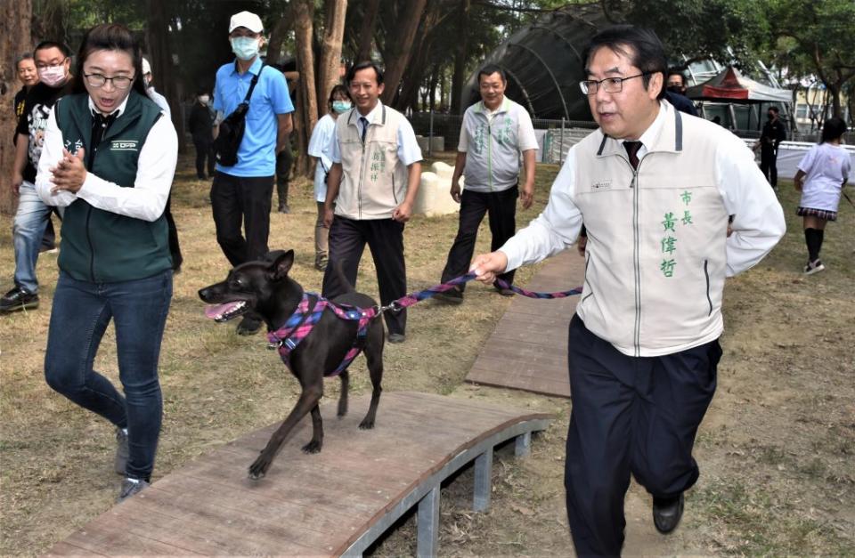 市長黃偉哲帶著愛犬黑妞體驗獨木橋設施。（記者翁聖權攝）