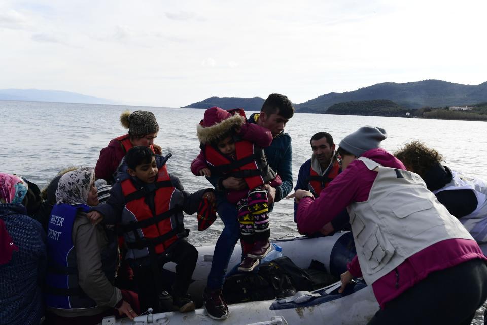 Refugees and migrants arrive with a dinghy at the village of Skala Sikaminias, on the Greek island of Lesbos, after crossing the Aegean sea from Turkey, on Friday, Feb. 28, 2020. An air strike by Syrian government forces killed scores of Turkish soldiers in northeast Syria, a Turkish official said Friday, marking the largest death toll for Turkey in a single day since it first intervened in Syria in 2016. (AP Photo/Micheal Varaklas)