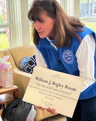 Director Karen Johnston shows Bill Begley a plaque stating that the large gymnasium and auditorium at the Weymouth Senior Center have been named in honor of his 30 years of service.