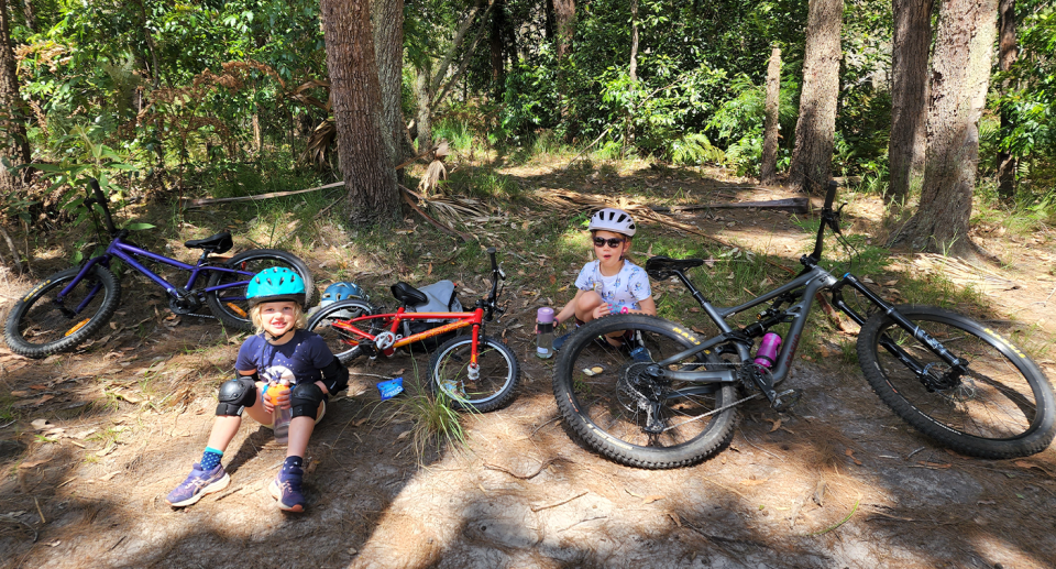 Mountain bike riders say the sport is a great way to enjoy nature. These two kids are seen taking a break from riding on another forest trail. Source: Dr Simon Kean