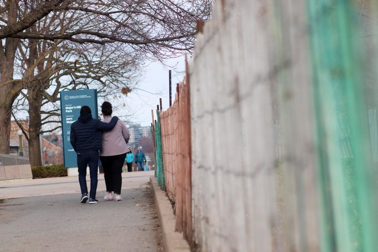 A couple walks along a path in Major's Hill Park in downtown Ottawa in April 2022. (Trevor Pritchard/CBC - image credit)