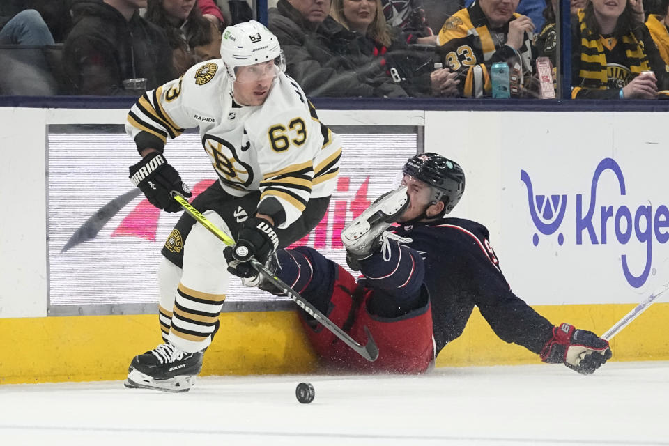 Boston Bruins left wing Brad Marchand (63) skates away from Columbus Blue Jackets center Jack Roslovic, right, in the second period of an NHL hockey game Tuesday, Jan. 2, 2024, in Columbus, Ohio. (AP Photo/Sue Ogrocki)