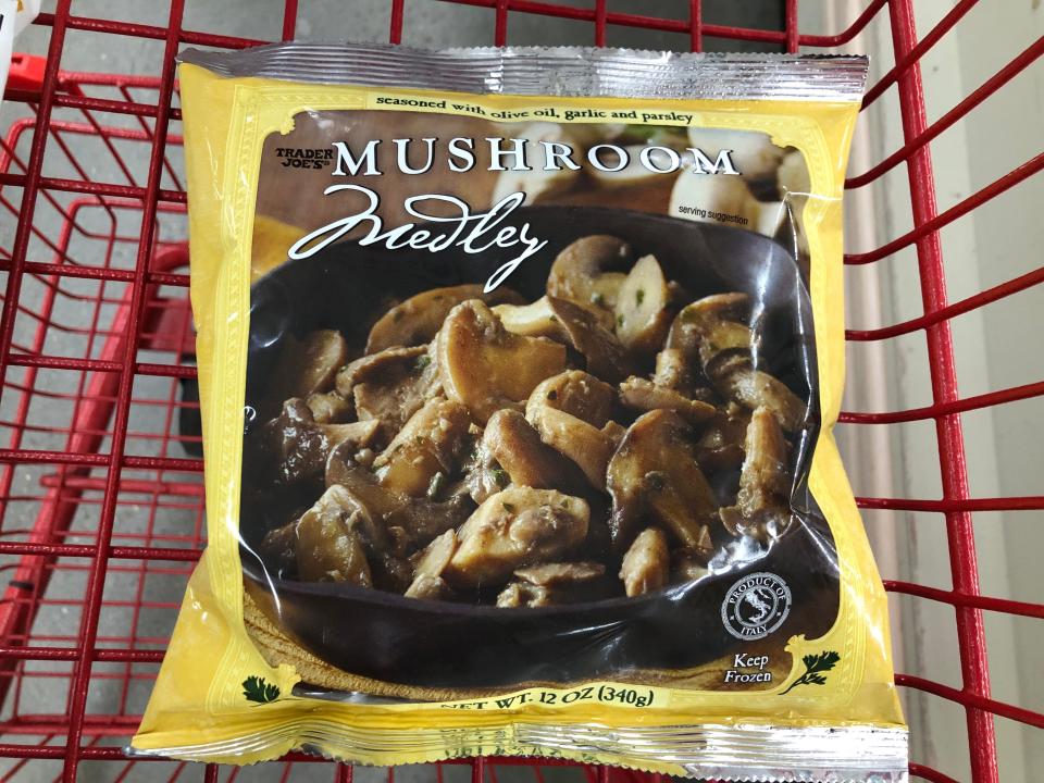 A bag of Trader Joe's mushroom medley in a red shopping cart.