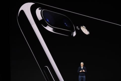 Cook in front of an image of the new iPhone 8 Plus - Credit: Bloomberg