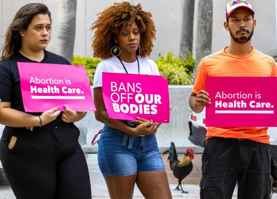 Planned Parenthood’s Miami-Dade regional organizer, Jessica Merino, left, holistic doula Nicky Dawkins, center, and local activist Libre, hold protest signs during a Florida Planned Parenthood PAC press conference at Stephen P. Clark Government Center in Miami, Florida, on Friday, June 24, 2022. The press conference was in response to the U.S. Supreme Court’s overturning the landmark abortion rights decision known as Roe v. Wade.