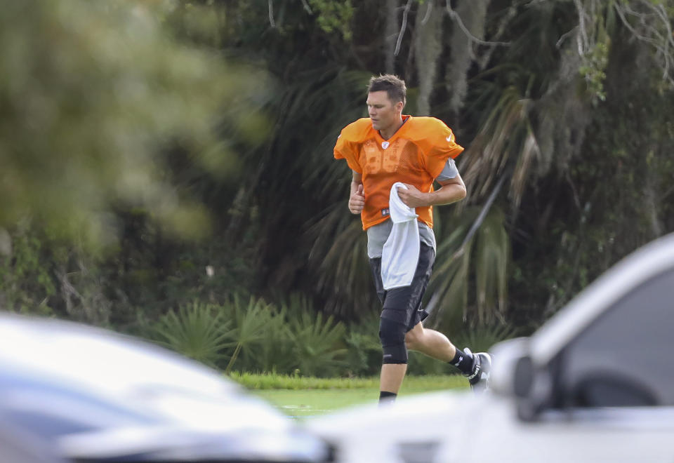 Tampa Bay Buccaneers NFL football quarterback Tom Brady runs across the field at Berkeley Preparatory School in Tampa, Fla., Tuesday, May 19, 2020. (Chris Urso/Tampa Bay Times via AP)