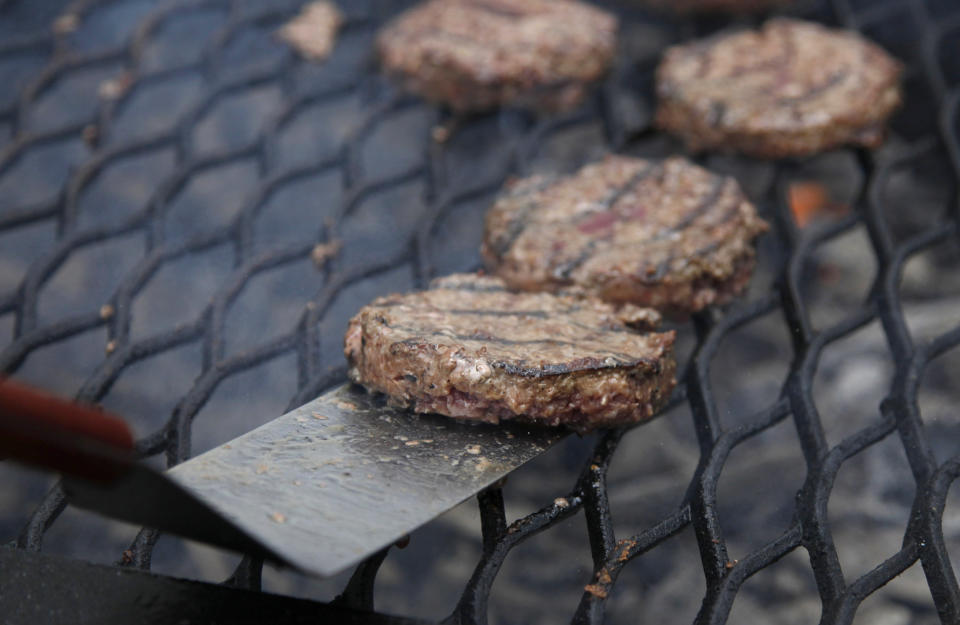 FILE - This Aug. 4, 2011 file photo shows hamburgers on a grill in Washington. (AP Photo/Carolyn Kaster, File)