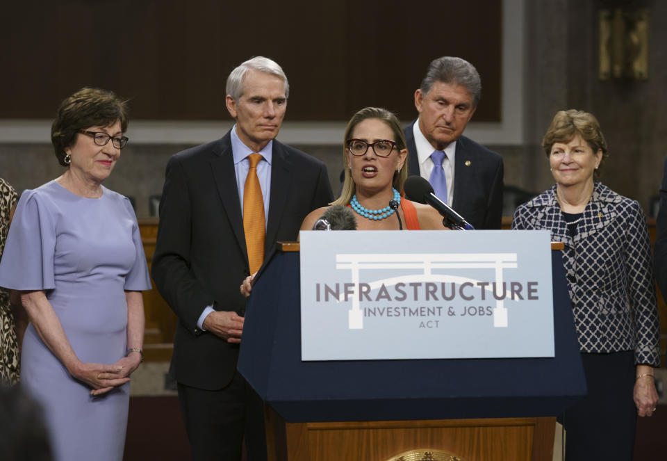 FILE - Sen. Kyrsten Sinema, D-Ariz., center, joined from left by, Sen. Susan Collins, R-Maine, Sen. Rob Portman, R-Ohio, Sen. Joe Manchin, D-W.Va., and Sen. Jeanne Shaheen, D-N.H., speaks to reporters just after a vote to start work on a nearly $1 trillion bipartisan infrastructure package, at the Capitol in Washington, July 28, 2021. The decision by Sinema to leave the Democratic Party raised the prospect of a tumultuous three-way race in one of the most politically competitive states in the U.S. It set off a scramble among potential Democratic and Republican candidates to assess whether they could win their party’s nomination. (AP Photo/J. Scott Applewhite, File)