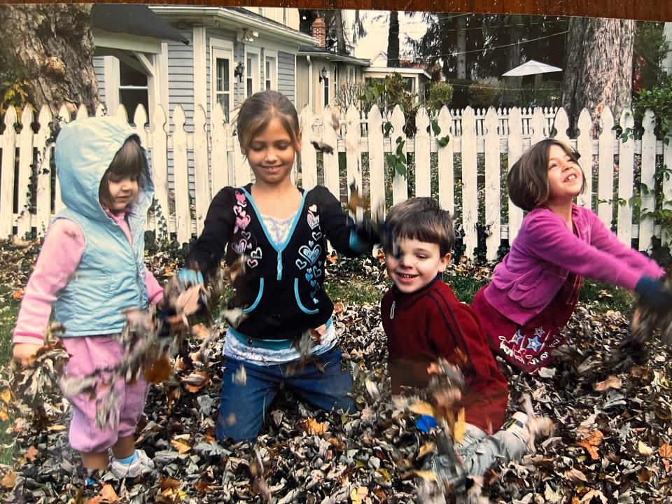 The Goodykoontz children play in leaves in Virginia, where there really is a fall season.