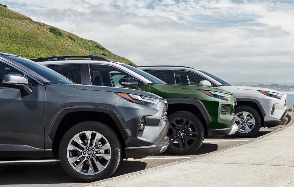 three rav4s parked on a road by a hill