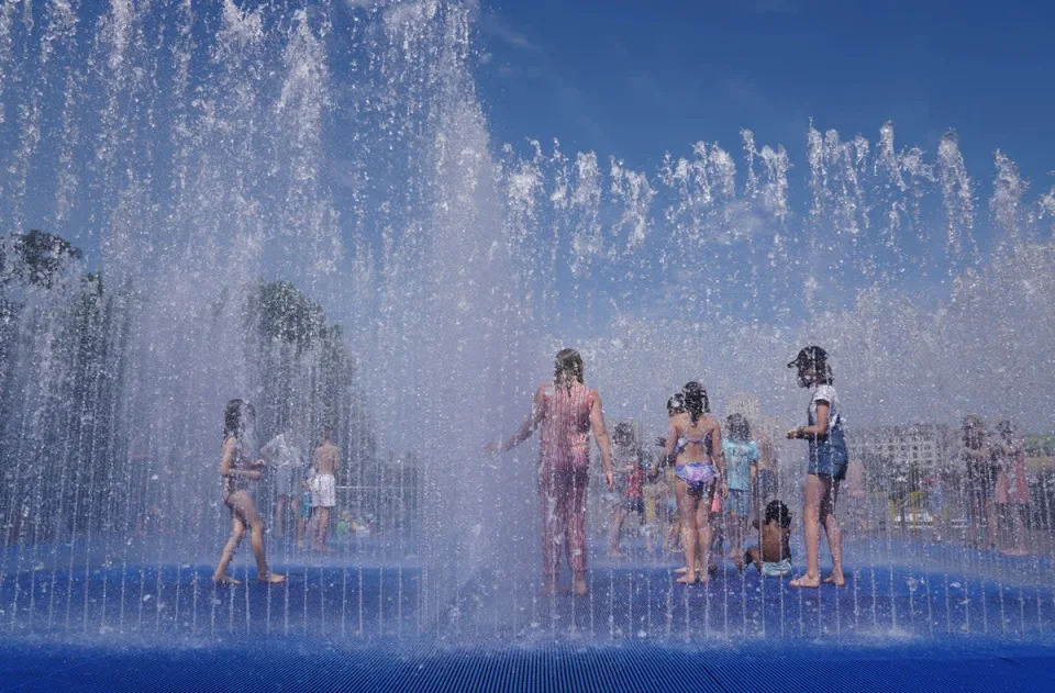 Children cool off in the Southbank Centre fountain during a heatwave in London (Reuters)