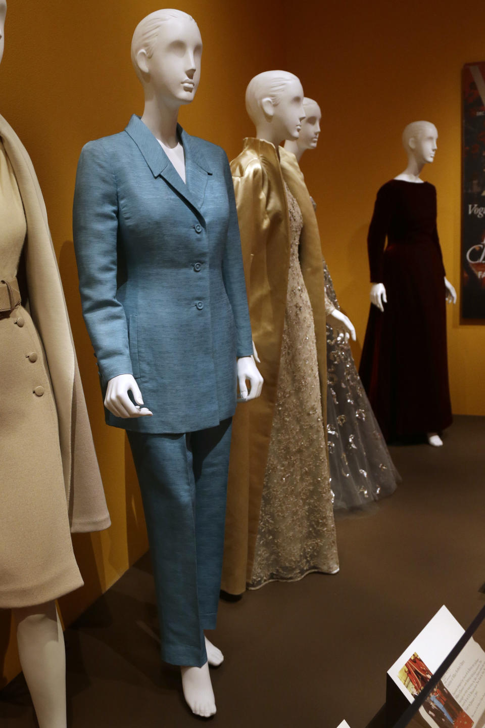 An Oscar de la Renta pantsuit, left, worn by former first lady Hillary Rodham Clinton, is displayed next to other creations by the designer at the Clinton Presidential Library in Little Rock, Ark., Monday, July8, 2013. The "Oscar de la Renta: American Icon" exhibit is on display at the Clinton library until Dec. 1. (AP Photo/Danny Johnston)