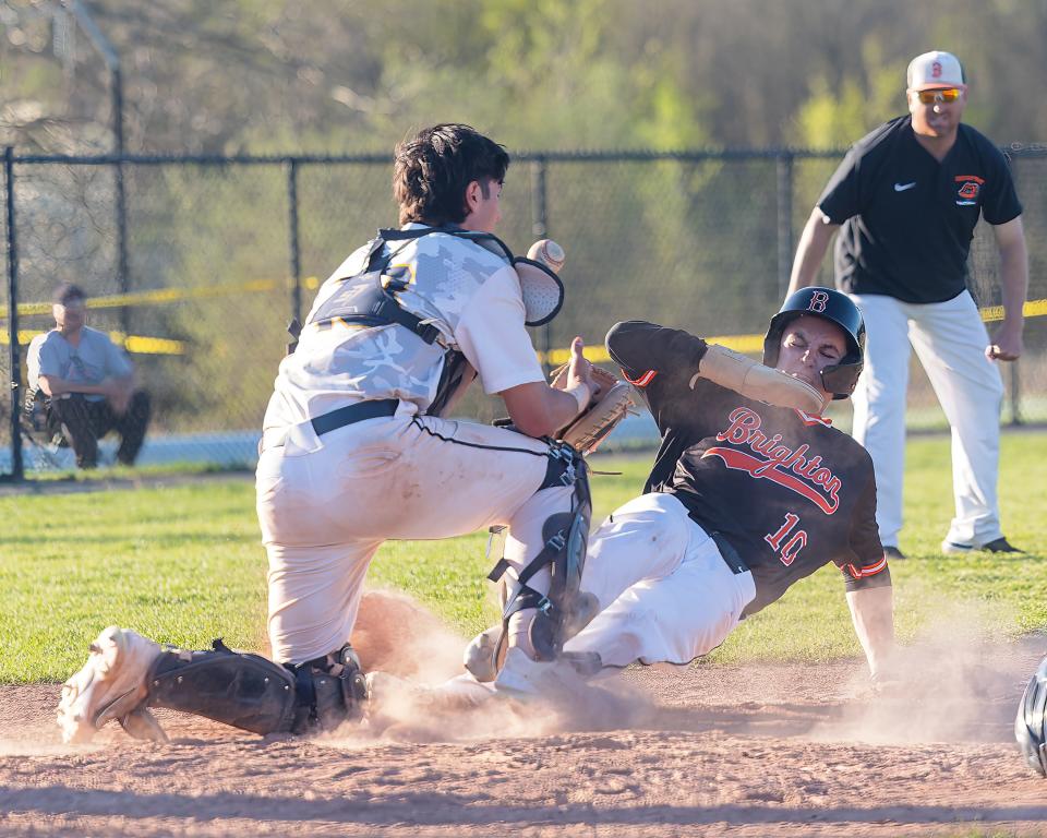 Brighton's Jack Renner (10) slides safely into home in the 10th inning as Hartland catcher Oscar Pace fields a throw Wednesday, May 1, 2024.