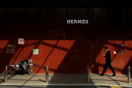A man walks past a Hermes store one day before the opening session of the National People's Congress (NPC) in Beijing