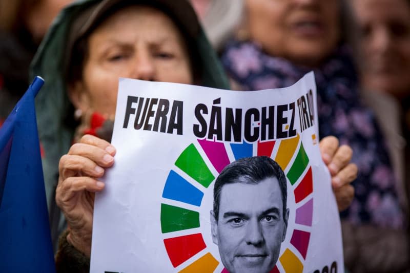 A woman carries a sign with the face of Pedro Sanchez, Prime Minister of Spain, during a demonstration called by the Freedom and Alternative Forum against the Spanish government's amnesty law for people who participated in the failed independence attempt of Catalonia in 2017. Luis Soto/ZUMA Press Wire/dpa