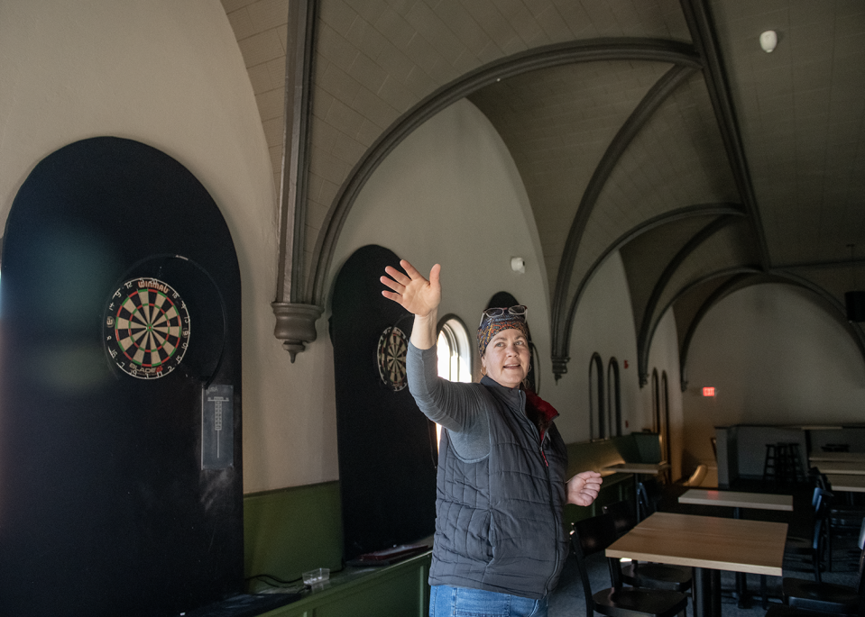 Jennifer Hermann, co-founder and head brewer at Bell Tower Brewing Co., stands on the building's second floor, which has dart boards for leagues that play three seasons a year and showcases the architecture of the building's former life as a church.