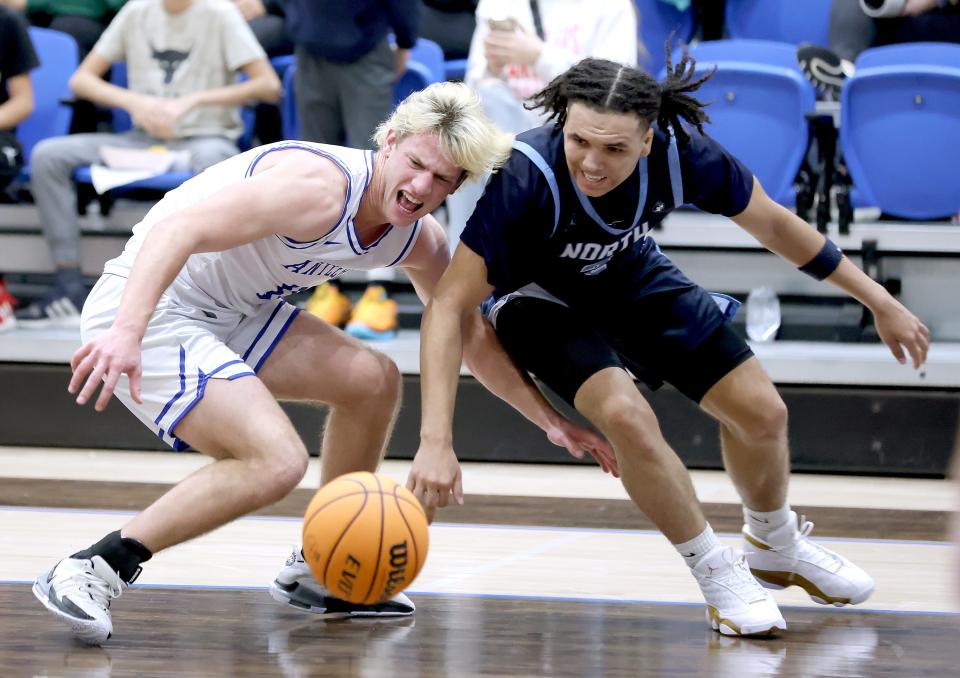 Deer Creek's Mason Smith, left, and Edmond North's Chiante' Tramble fight for a loose ball during the boys high school game between Deer Creek and Edmond North at Deer Creek High School, Friday, Jan. 26, 2024.