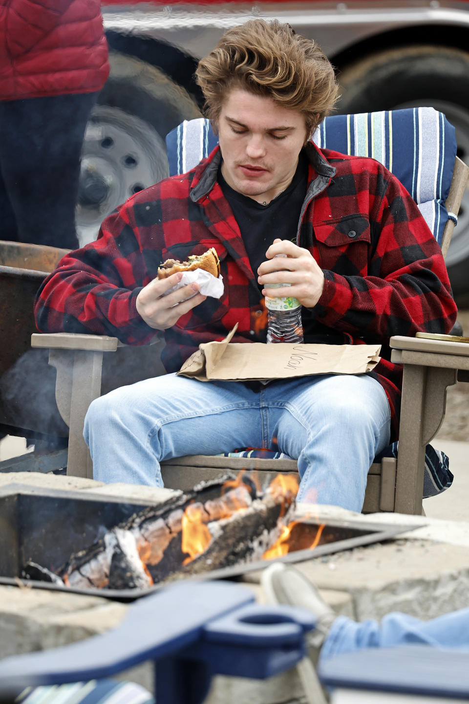 Noah Hartford, a student at Sandhills Community College and a resident of Aberdeen, N.C., has lunch while the power is out at his home, at Red's Food Truck Corner in Southern Pines, N.C., Monday, Dec. 5, 2022. (AP Photo/Karl B DeBlaker)