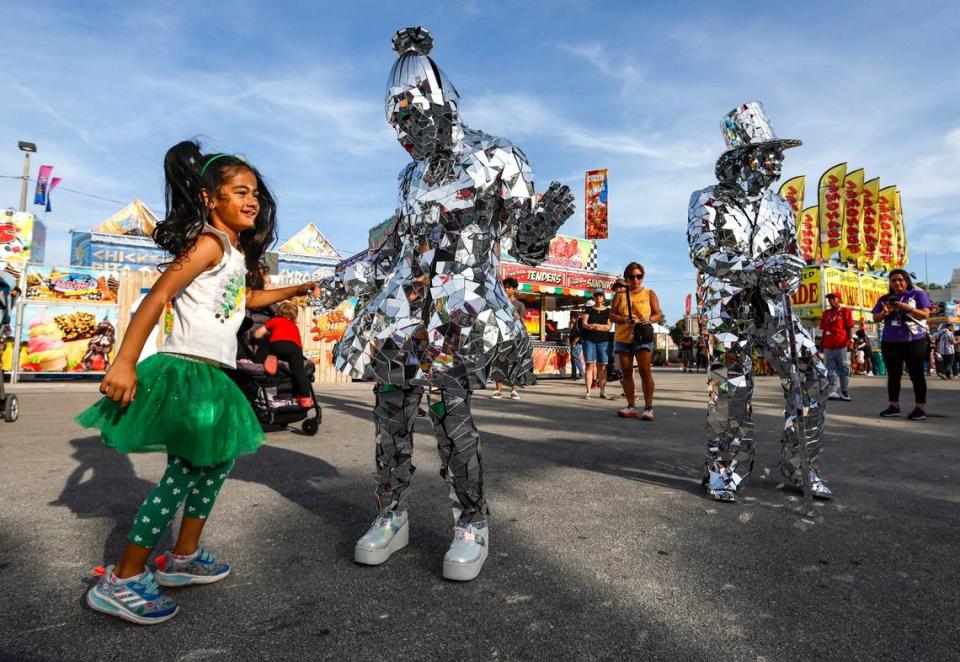 Yvette Ramberan, 5, dances with Shimer & Shine during the 2024 Miami-Dade County Youth Fair & Exposition. The theme of the 72nd edition is “Spaceventure,” held in Miami on Thursday, March 14, 2024. Shine is on the left played by Michelle Peters and Caleb Labarre on the right.