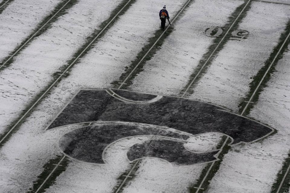 A worker clears yard lines before an NCAA college football game between Iowa State and Kansas State after a winter storm dumped about 4 inches of snow on the area Saturday, Nov. 25, 2023, in Manhattan, Kan. (AP Photo/Charlie Riedel)