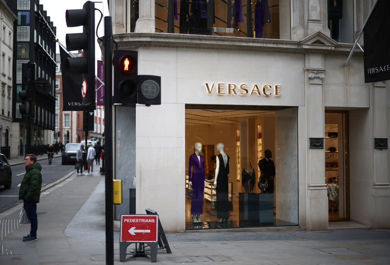 Person stands outside a Versace store on New Bond Street in London