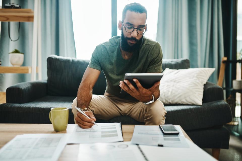 man sitting at coffee table doing taxes