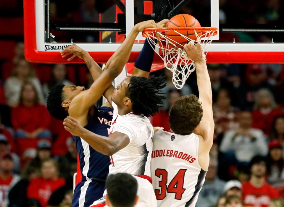 Virginia’s Ryan Dunn dunks over N.C. State’s Dennis Parker Jr. and Ben Middlebrooks during the first half of the Wolfpack’s game on Saturday, Jan. 6, 2024, at PNC Arena in Raleigh, N.C.