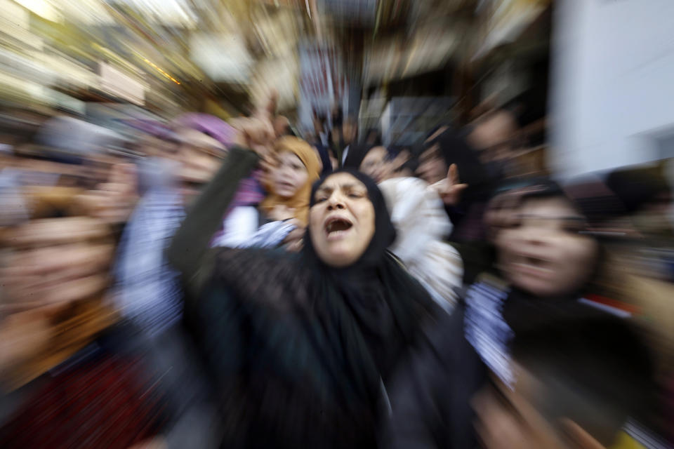 In this photo made with a slow shutter speed, Palestinian chant slogans against Israel and U.S. President Donald Trump, during a protest against the White House plan for ending the Israeli-Palestinian conflict, at Burj al-Barajneh refugee camp, south of Beirut, Lebanon, Friday, Jan. 31, 2020. (AP Photo/Bilal Hussein)