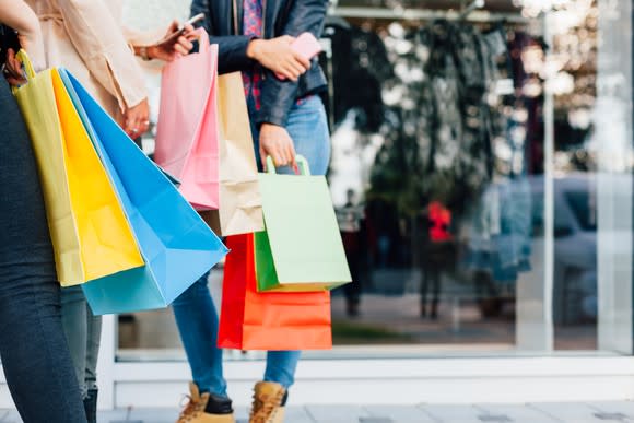 People carry shopping bags.