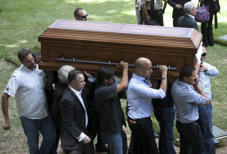 Parientes y amigos cargan el féretro con los restos del ex esposo de Mónica Spear, Thomas Henry Berry, el viernes 10 de enero del 2014 en el Cementerio del Este en Caracas. La ex Miss Venezuela y actriz de 29 años y su ex marido, de 39, fueron asesinados a tiros por delincuentes que los asaltaron en una autopista desolada la noche del lunes, mientras se encontraban en el país de vacaciones. Su hija de 5 años fue herida en una pierna. (AP Foto/Alejandro Cegarra)