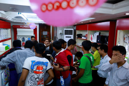 FILE PHOTO: People gather in a shop to buy SIM cards from Qatar's Ooredoo at a phone shop in Yangon July 31, 2014. REUTERS/Soe Zeya Tun/File Photo